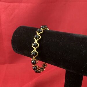 Gold tone wire with black plastic beads bracelet